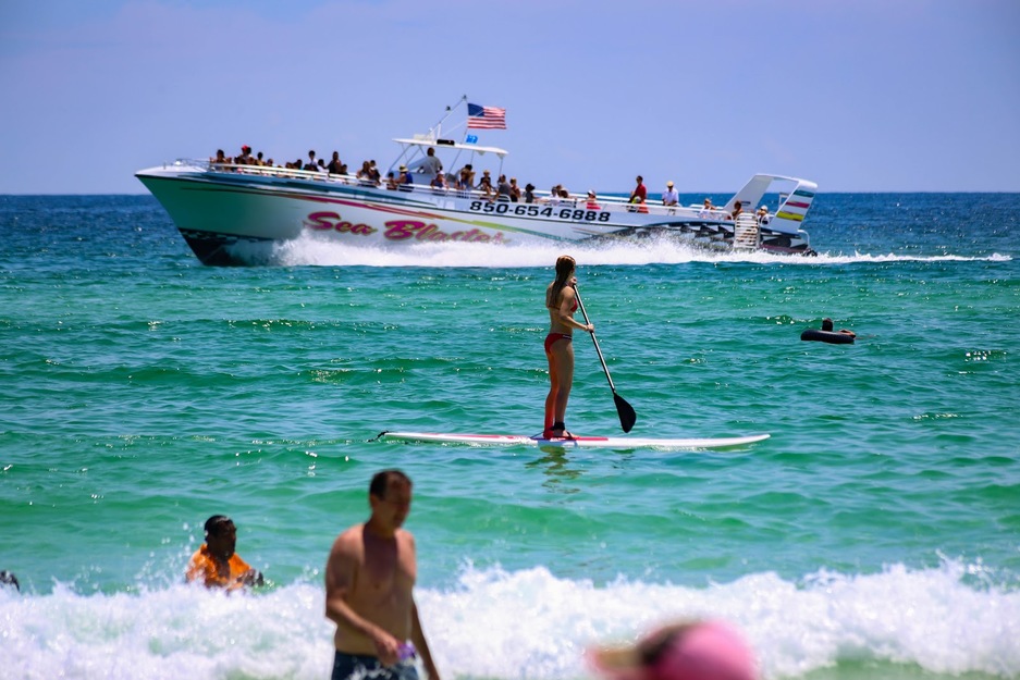 A large boat and a woman on a paddleboard