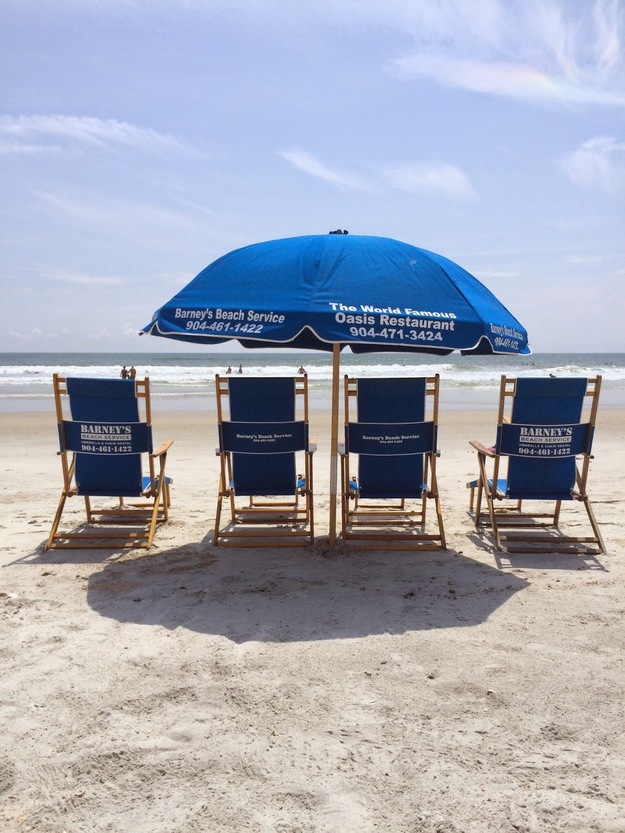 Beach chairs and a blue umbrella