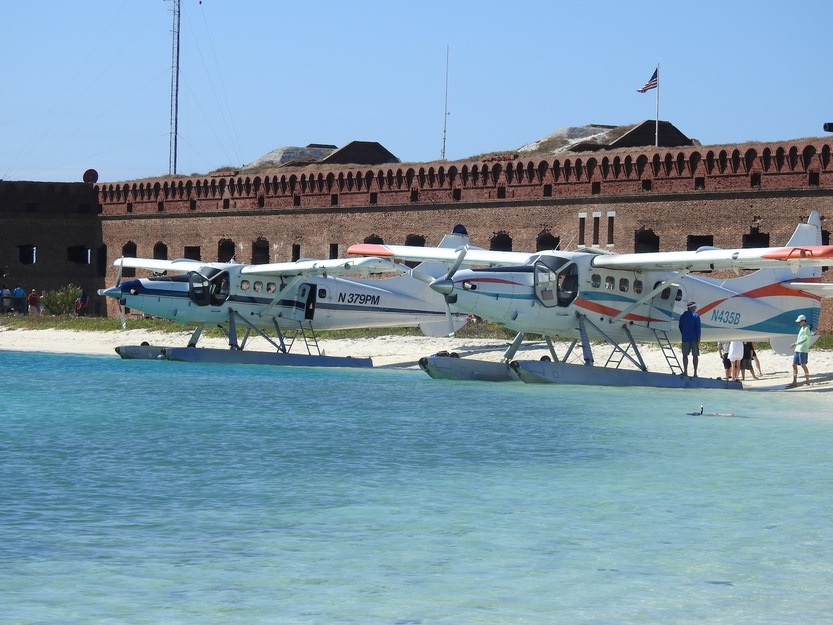 Planes on water against a fortress wall