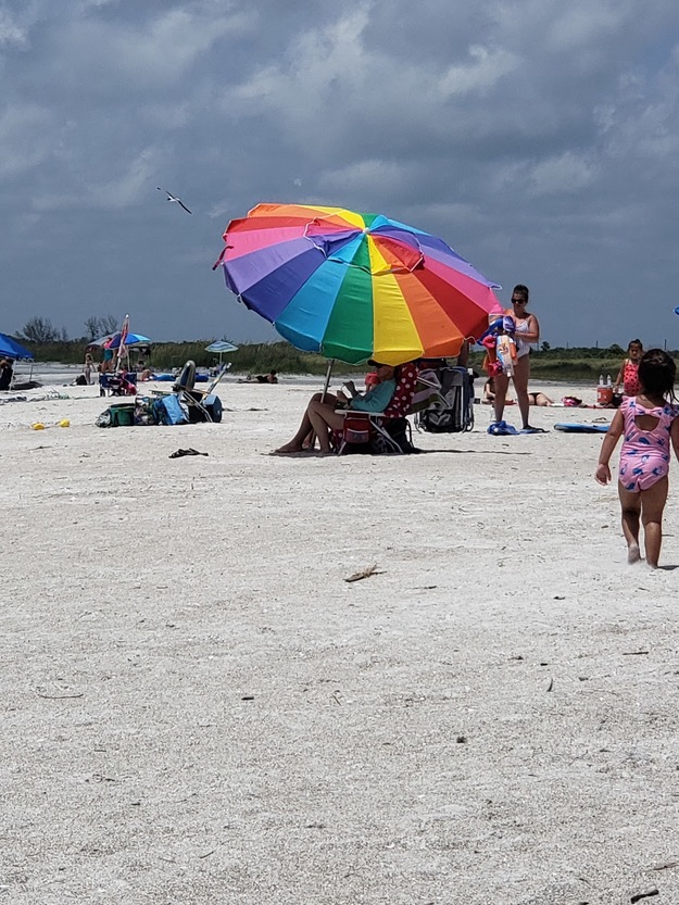 A rainbow umbrella on the beach