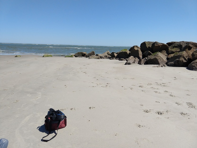 A bag on the sand and rocks on the beach