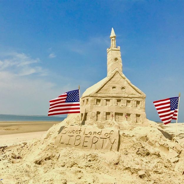 Sandcastle with two American flags