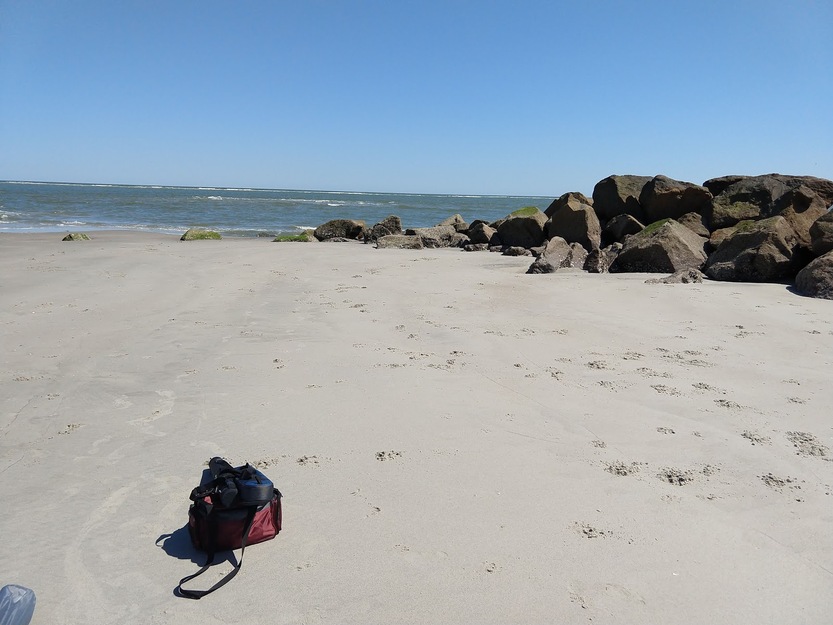 A bag on the sand and rocks on the beach