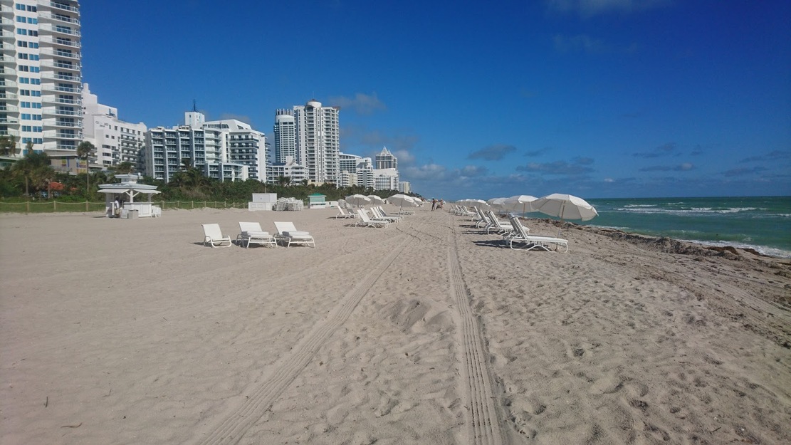 Hotels and white sunbeds on the beach