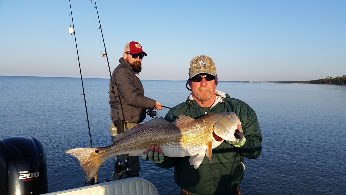 Fishermen with a large fish on St. Vincent National Wildlife Refuge Beach
